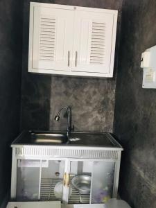 une cuisine avec un évier et un placard dans l'établissement xaythone guest house, à Savannakhet