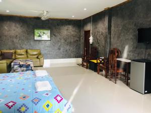 Zimmer mit einem Bett, einem Sofa und einem Tisch in der Unterkunft xaythone guest house in Savannakhet