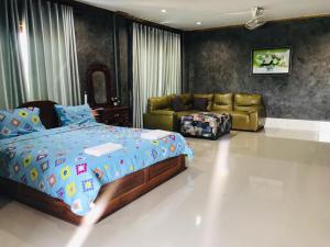 a bedroom with a bed and a couch and a bed and a room with at xaythone guest house in Savannakhet