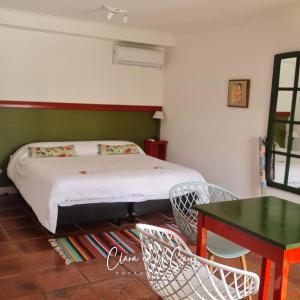 a bedroom with a bed and a table and chairs at Clara en el Cerro in Tandil