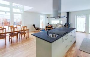 een keuken en een woonkamer met een tafel en stoelen bij Stunning Home In Bstad With Wifi in Båstad
