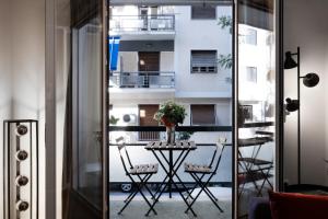 um quarto com uma mesa e cadeiras e uma varanda em Rare 1BR APT, next to the new Goulandris Museum em Atenas