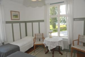 a bedroom with two beds and a table and a window at Bruksgården 