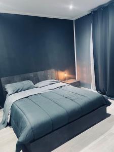 una camera con un grande letto con una parete blu di Delizioso Appartamento a Ceglie Messapica