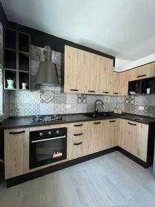 una cucina con armadi in legno e piano cottura di Delizioso Appartamento a Ceglie Messapica