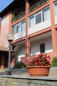 um edifício com um vaso de flores em frente em I Due Camini em Baraggia di Boca