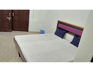 ChaukhandiにあるHotel New Ashoka,Prayagrajの青い枕付きのベッド1台