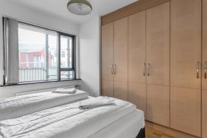 a bedroom with two beds and a window at Sunny Apartment - By the Sea in City Center in Reykjavík