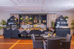 a restaurant with a buffet with tables and chairs at Ravensberger Hof in Bielefeld