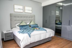 a bedroom with a large bed with blue pillows at 253 on Ipahla in Amanzimtoti
