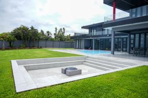 a modern house with a fire pit in the yard at 253 on Ipahla in Amanzimtoti +30 photos