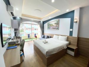 Schlafzimmer mit einem Bett, einem Schreibtisch und einem TV in der Unterkunft Home Away Homestay, City Center, D1 in Ho-Chi-Minh-Stadt