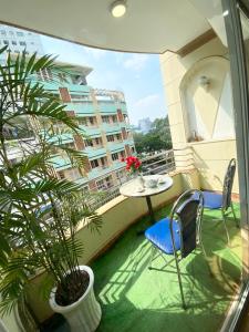 un balcon avec une table, des chaises et une plante dans l'établissement Home Away Do Quang Dau- Homestay, City Center, D1, à Hô-Chi-Minh-Ville