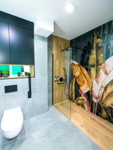 La salle de bains est pourvue d'une douche et de toilettes. dans l'établissement Aparthotel Green Concrete - nowy, ekologiczny hotel w Świnoujściu, à Świnoujście