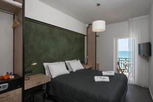 a bedroom with a bed and a desk and a window at Pelagia Sea Side in Acharavi