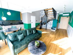 ein Wohnzimmer mit einem Sofa und einem Tisch in der Unterkunft Aparthotel Green Concrete - nowy, ekologiczny hotel w Świnoujściu in Świnoujście