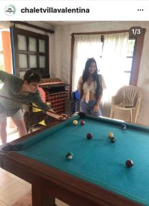 un hombre y una mujer jugando al billar en Villa Valentina en La Tebaida