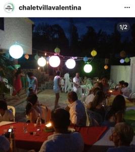 un grupo de personas sentadas en un restaurante por la noche en Villa Valentina en La Tebaida