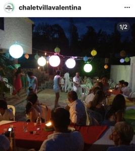 un groupe de personnes assises dans un restaurant la nuit dans l'établissement Villa Valentina, à La Tebaida