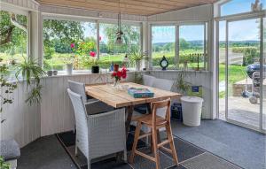 2 Bedroom Amazing Home In Havstenshult : شاشة في الشرفة مع طاولة وكراسي خشبية
