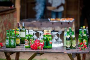 un grupo de botellas de cerveza sobre una mesa de madera en Paradis Malahide, en Gisenyi
