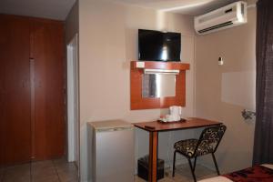 een kleine kamer met een tafel en een stoel bij Scenery Guesthouse Stadium in Maseru