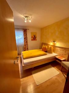 ウムハウゼンにあるLandhaus Rolandのベッドルーム1室(黄色いシーツ付きのベッド1台、窓付)
