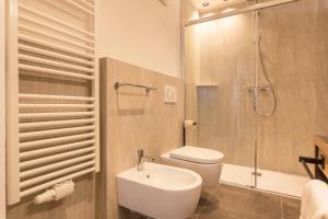 a bathroom with a toilet and a shower and a sink at Planerhof Apartment Edelweiss in Funes