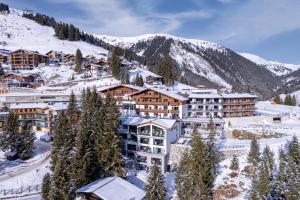 a resort in the mountains with snow on it at Ursprung Panorama Hotel Königsleiten in Königsleiten