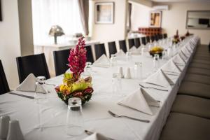 una mesa larga con mantel blanco y flores. en New Brookfields Hotel en Freetown