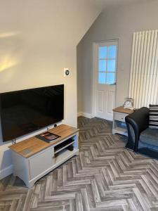 a living room with a flat screen tv and a couch at House In Padfield in Tintwistle