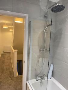 a bathroom with a shower and a sink and a tub at House In Padfield in Tintwistle