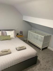 a bedroom with a white bed and a crib at House In Padfield in Tintwistle
