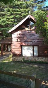 a log cabin with a window on the side of it at Cabaña de los Tres Pinos in Sierra de los Padres