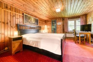 ビュルサーベルクにあるBerghaus Tschengla by A-Appartmentsの木製の部屋に大型ベッドが備わるベッドルーム1室が備わります。