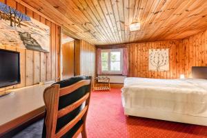 1 dormitorio con 1 cama y TV en una habitación en Berghaus Tschengla by A-Appartments en Bürserberg