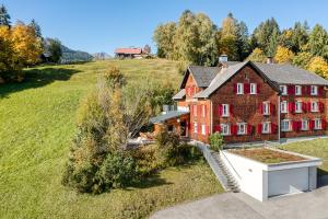 an aerial view of a large brick house in a field at Berghaus Tschengla by A-Appartments in Bürserberg