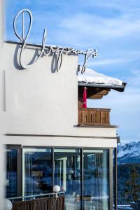 um sinal para um restaurante na lateral de um edifício em URSPRUNG Panorama Hotel Königsleiten em Königsleiten