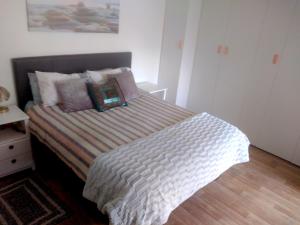 a bedroom with a bed with a striped comforter at Fisherhaven Guest House in Hermanus