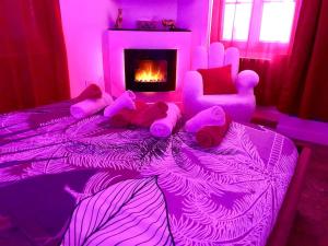Dormitorio púrpura con 2 camas con ositos de peluche y chimenea en La lover’s jungle, en Pont-sur-Yonne
