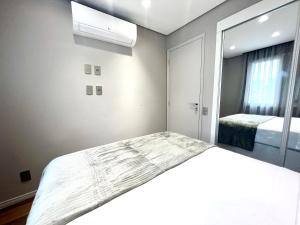 a bedroom with a large bed and a window at Flat 2 quartos a 2 quadras da paulista com garagem in São Paulo