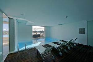 Zimmer mit einem Pool mit Stühlen und einem großen Fenster in der Unterkunft Pousada Palacio de Estoi – Small Luxury Hotels of the World in Estói
