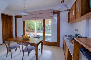 une cuisine avec une table et des chaises ainsi qu'une salle à manger dans l'établissement O2 Villas Yala, à Yala