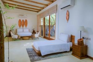 a bedroom with a white bed and a living room at O2 Villas Yala in Yala