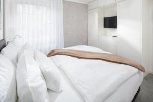 ein Schlafzimmer mit einem weißen Bett mit weißen Kissen in der Unterkunft Damenpfadpalais in Norderney