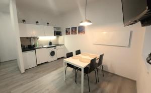 - une cuisine et une salle à manger avec une table et des chaises dans l'établissement DeLux12, à Łódź