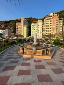 a fountain in the middle of a city with buildings at Huong Cang Sea View Hotel in Cat Ba