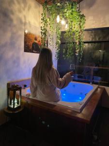 a woman sitting in a tub with a glass of wine at Recanto Lira I in Monte Verde