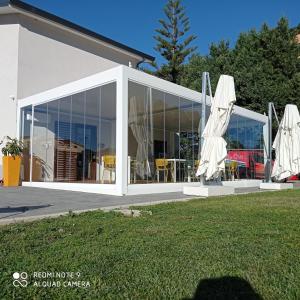 um conservatório branco com portas de vidro numa casa em Naturamare B&B em Villapiana