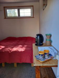 a room with a bed and a table with a tea pot at Aguaymanto in Cuchilla Alta